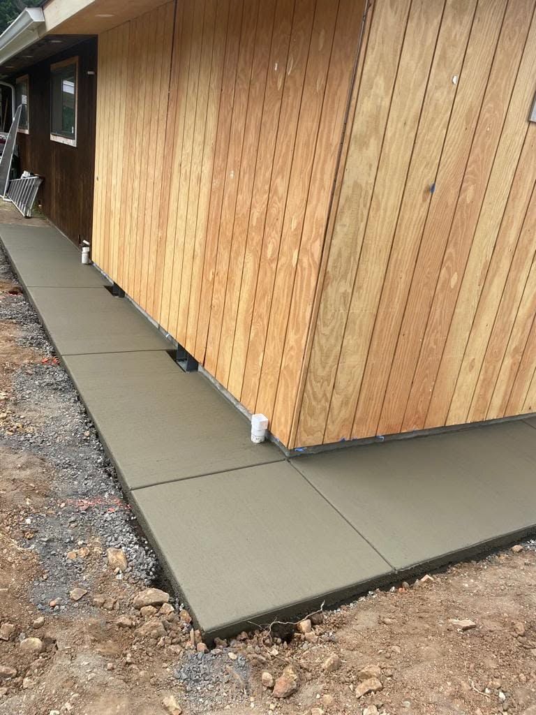 A sidewalk is being built in front of a house.