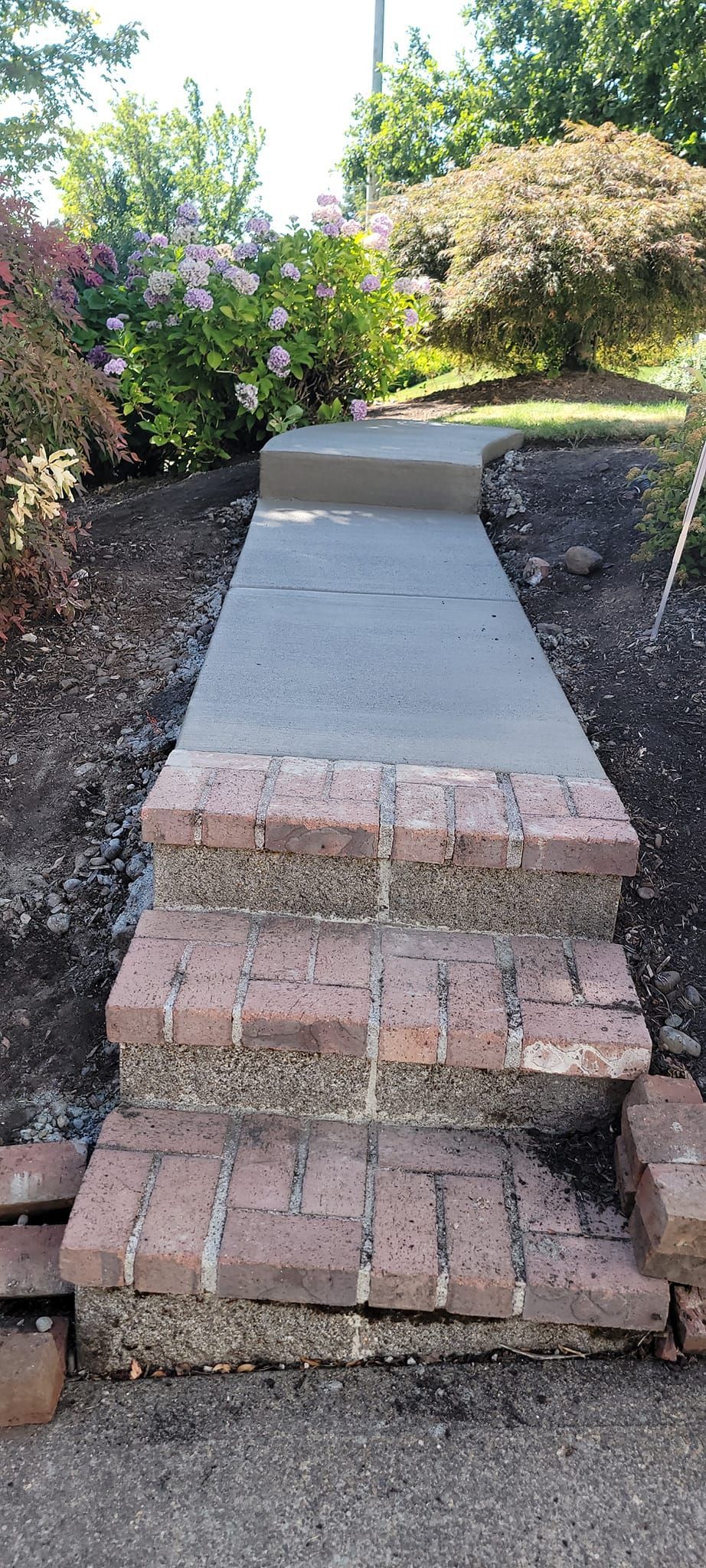 A brick walkway with steps leading up to a house.