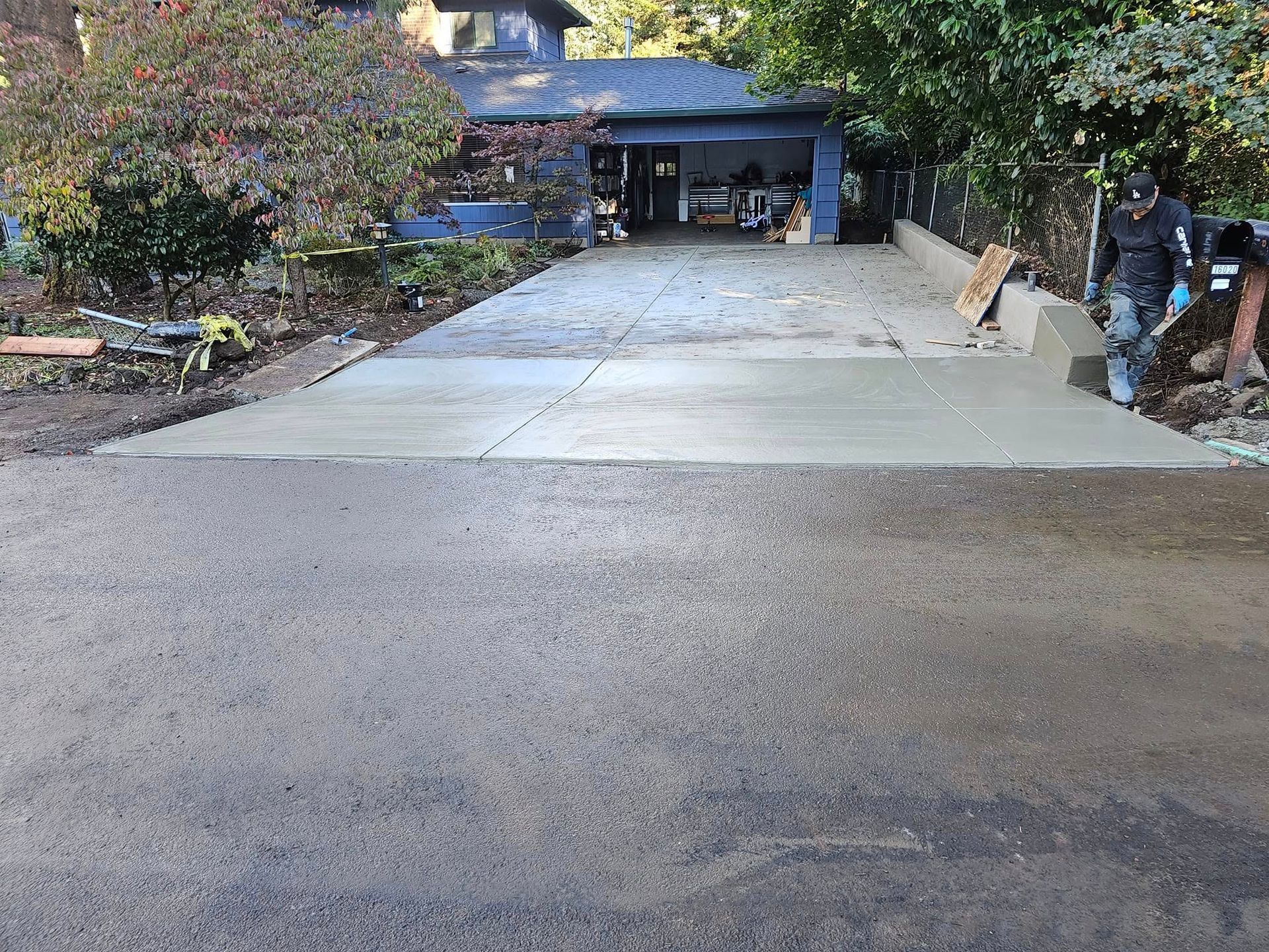 A concrete driveway is being built in front of a house.