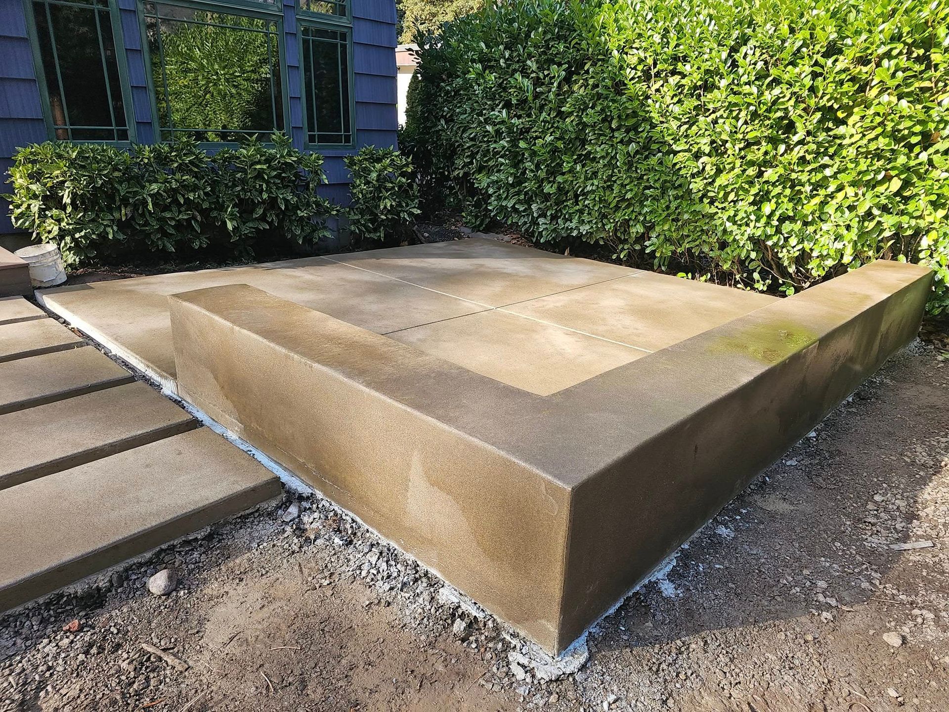 A concrete block is sitting in the dirt in front of a house