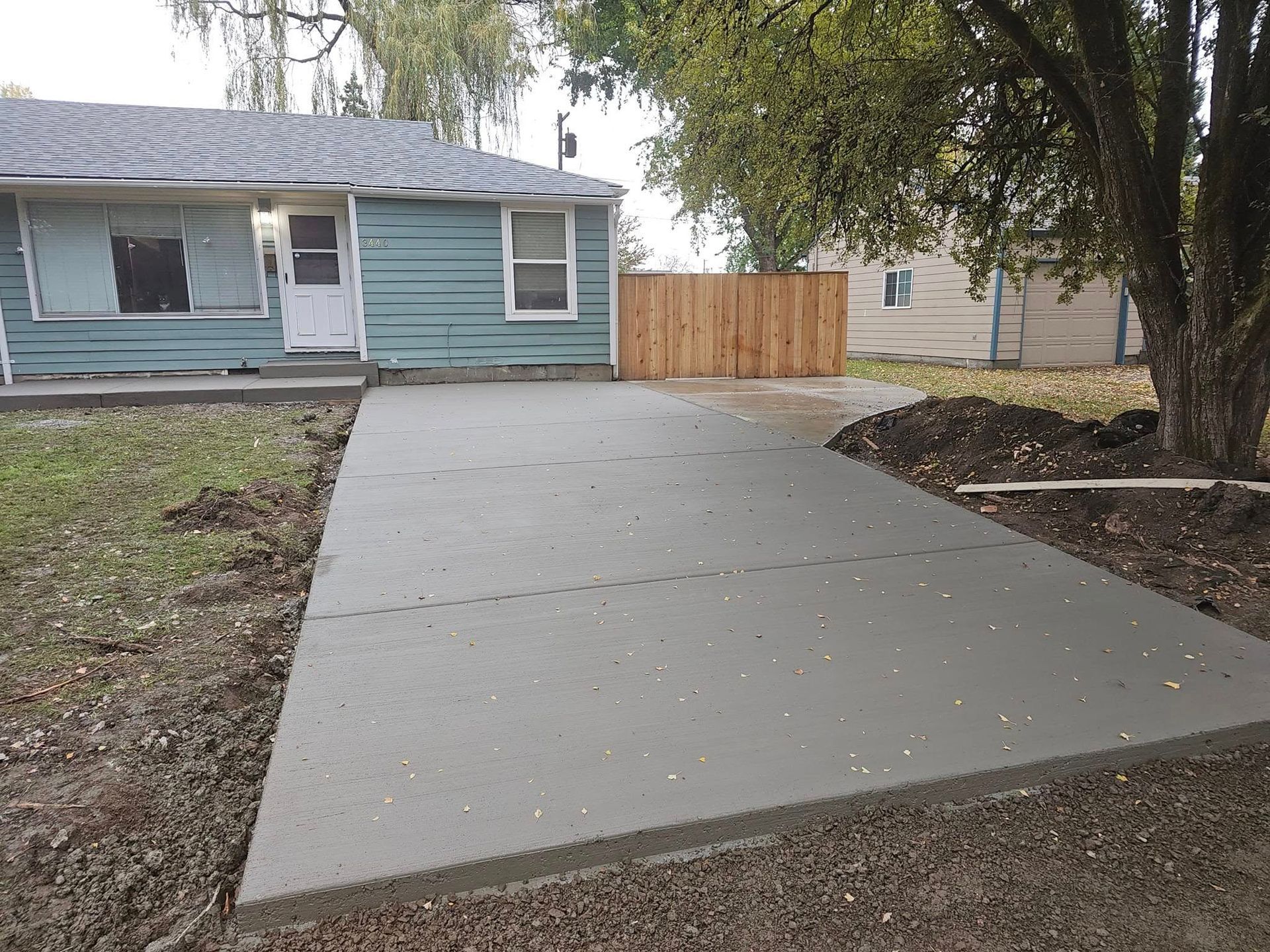 A concrete driveway is being built in front of a house.