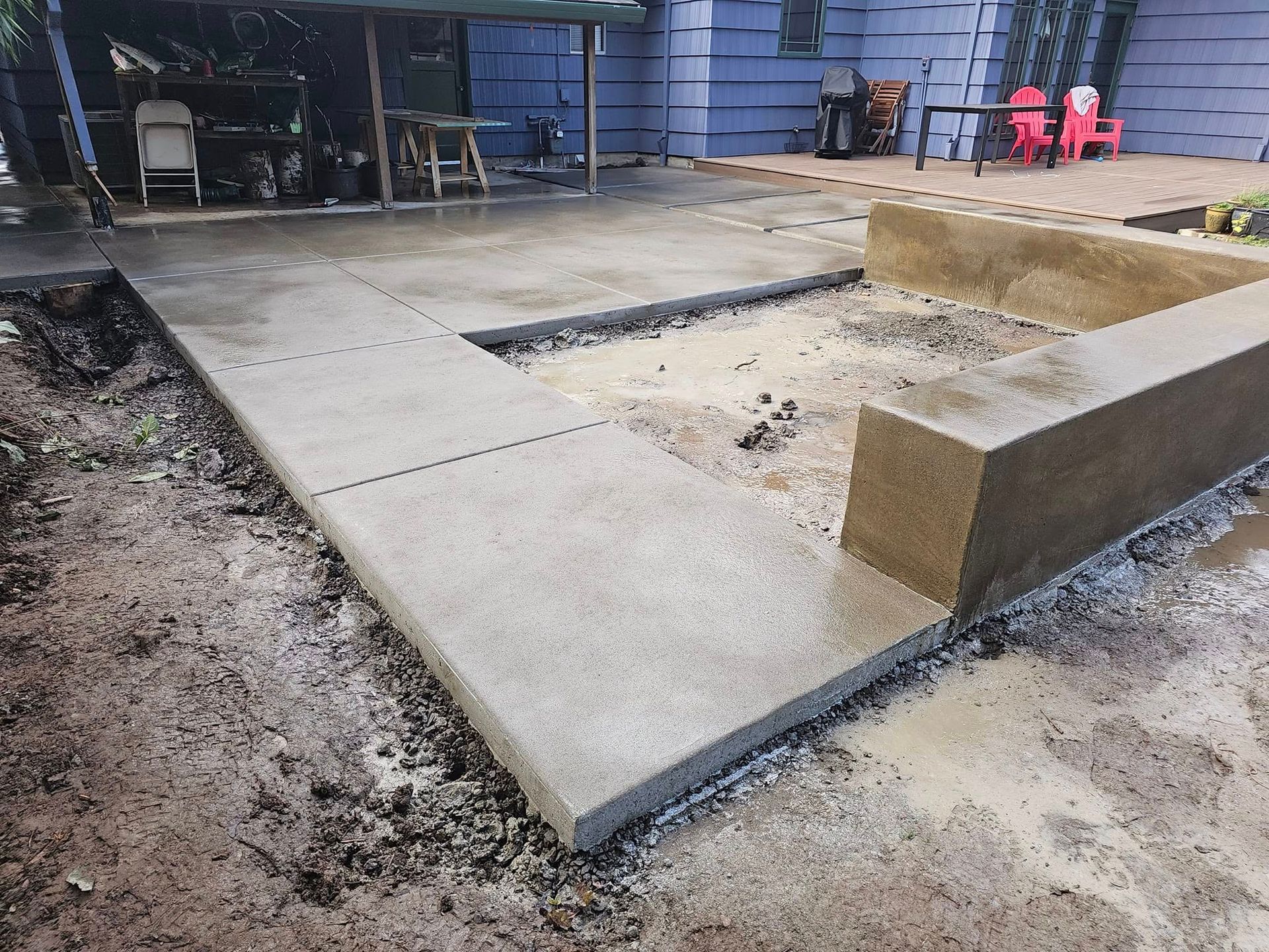A concrete walkway is being built in front of a house.