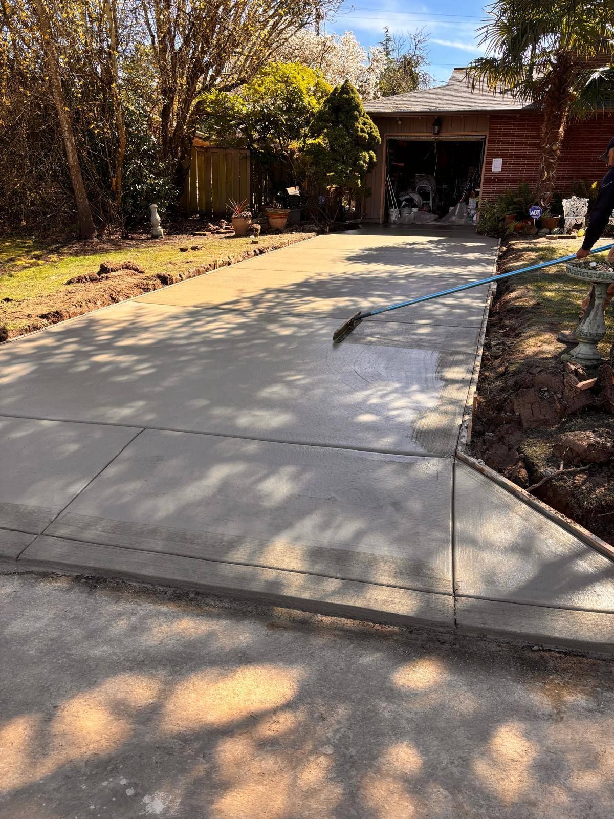 A concrete driveway is being built in front of a house.