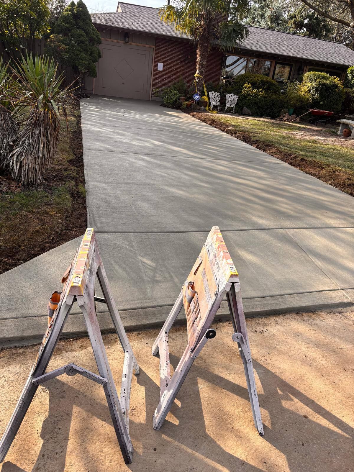 A concrete driveway is being built in front of a house.