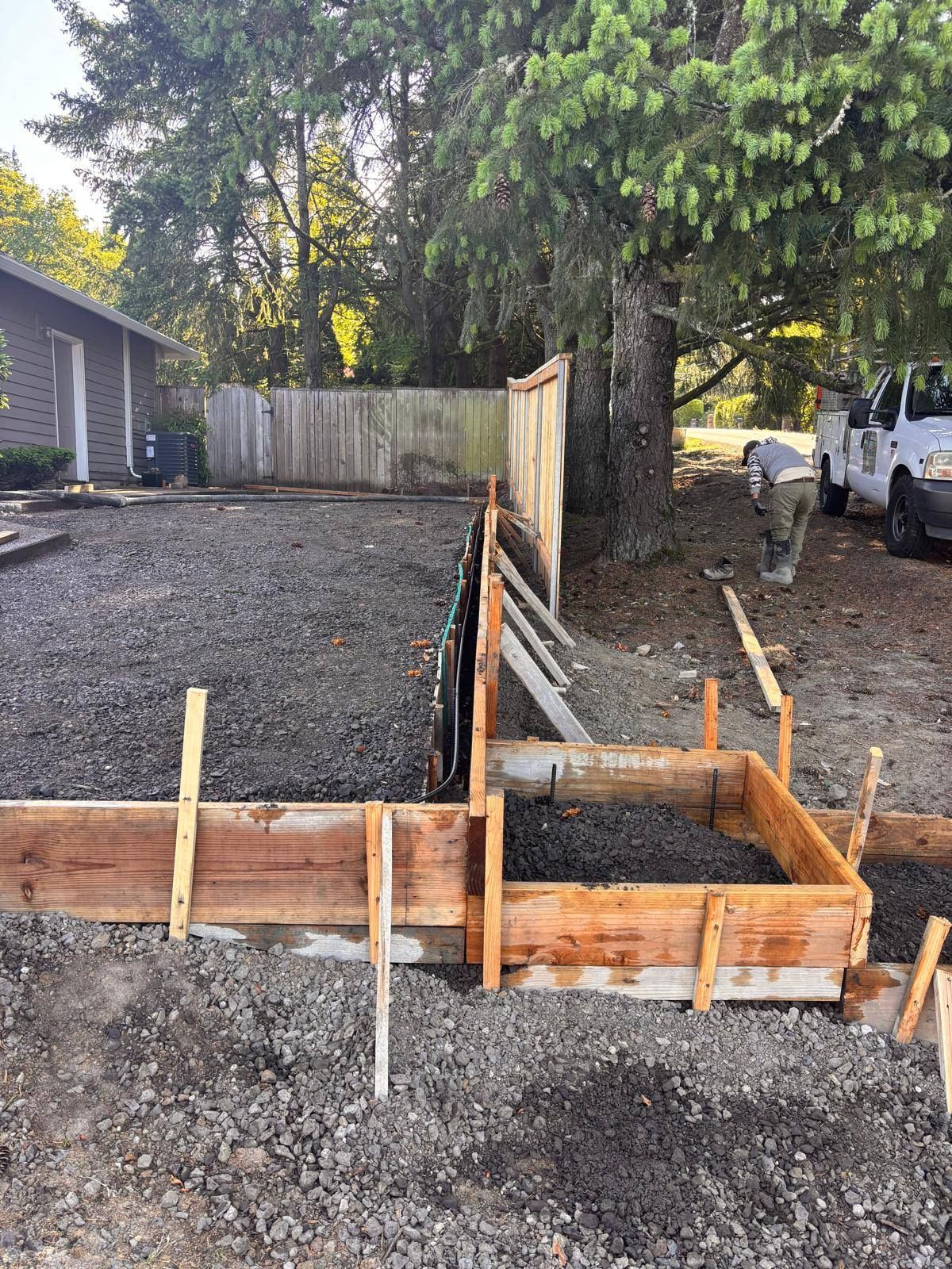 A concrete driveway is being built in front of a house.