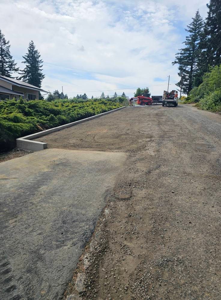 A dirt road with a red truck parked on the side of it.