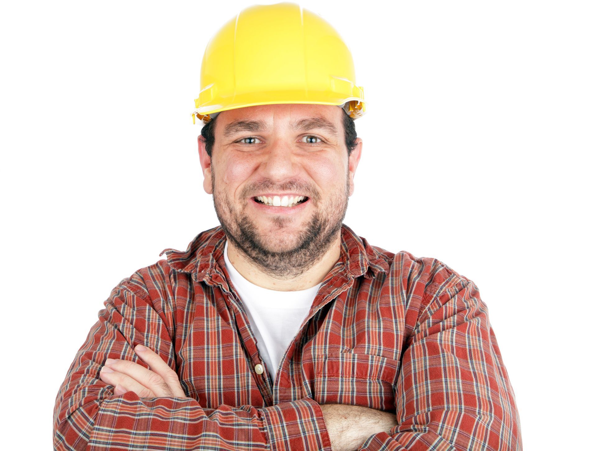 A man wearing a hard hat and plaid shirt is smiling with his arms crossed.