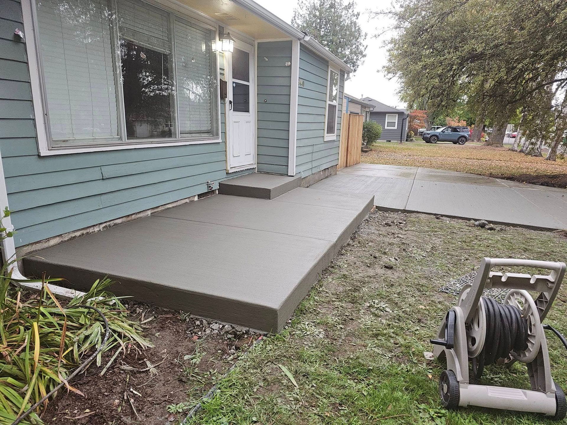 A concrete walkway is being built in a backyard.