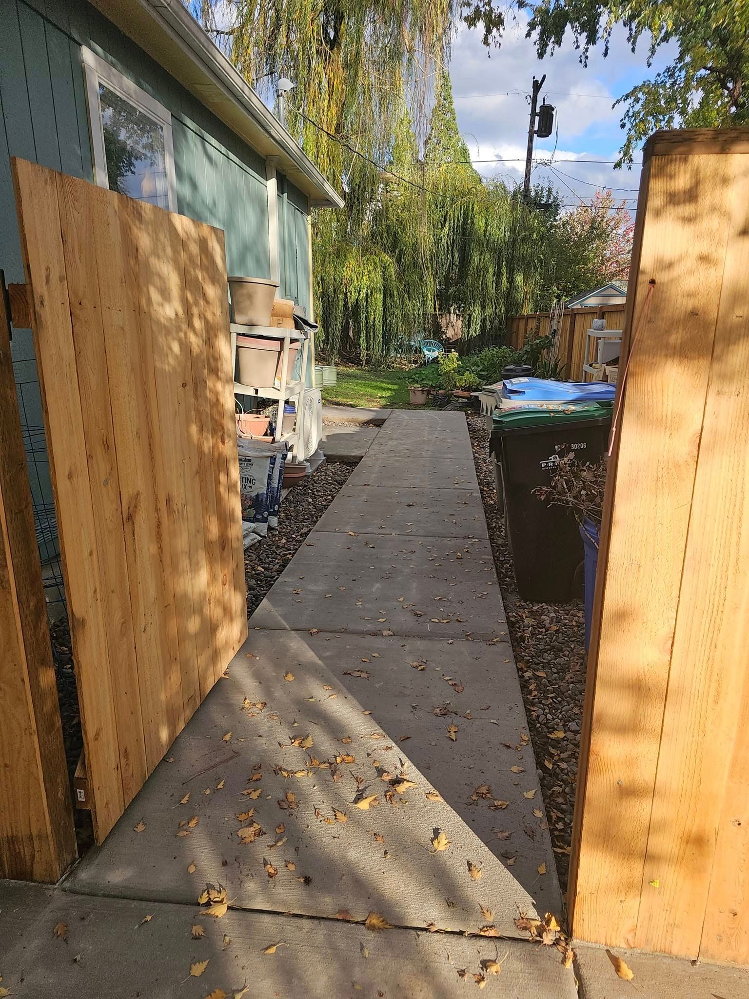 A man is standing on a concrete patio in front of a shed.