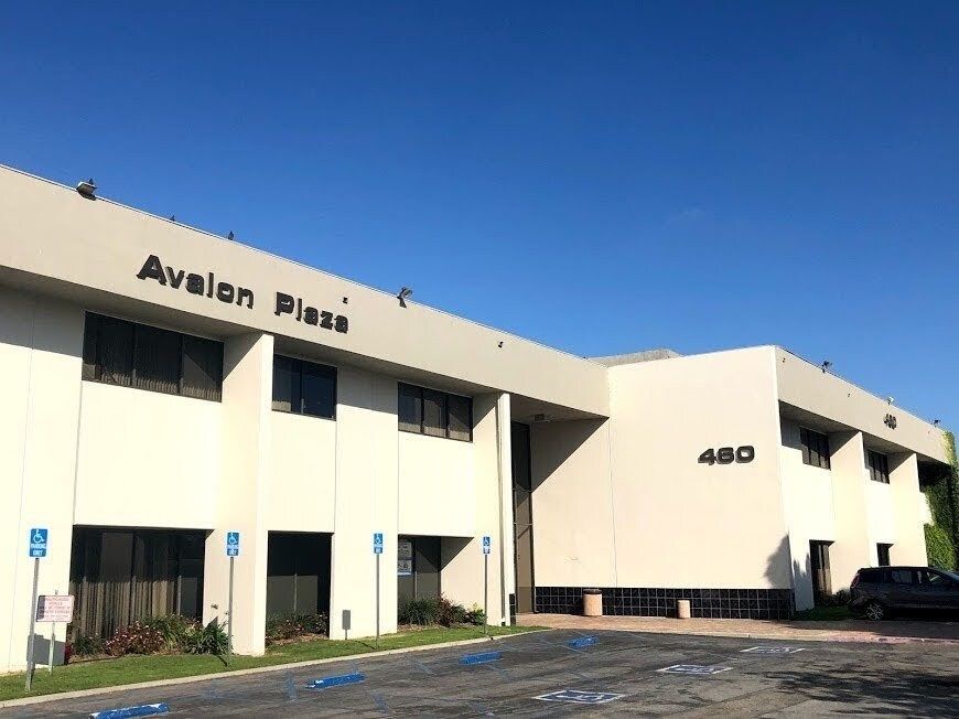 Modern building with wood and glass facade, blue sky.
