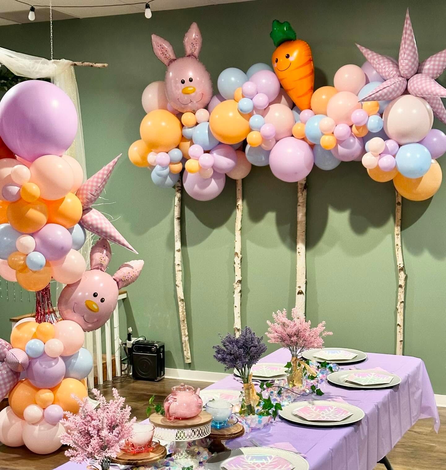 A table with plates and a bunch of balloons on it