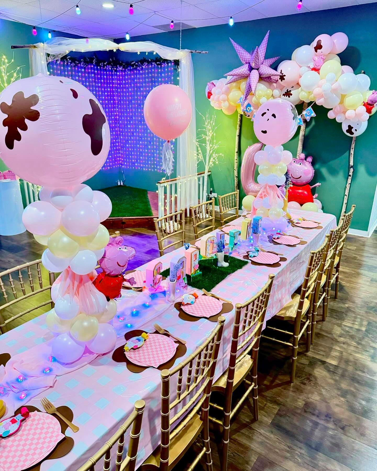 A long table decorated with balloons and plates for a birthday party.