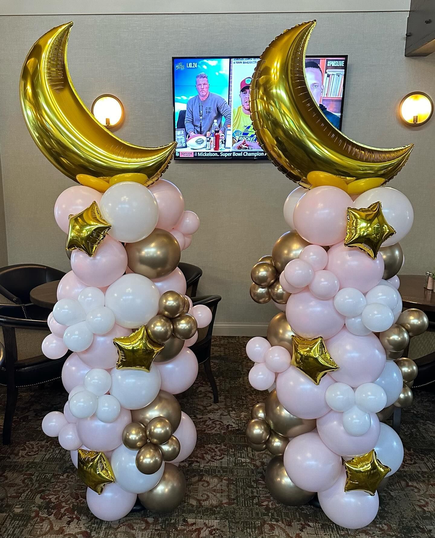 A couple of columns made of balloons with a crescent moon on top of them.