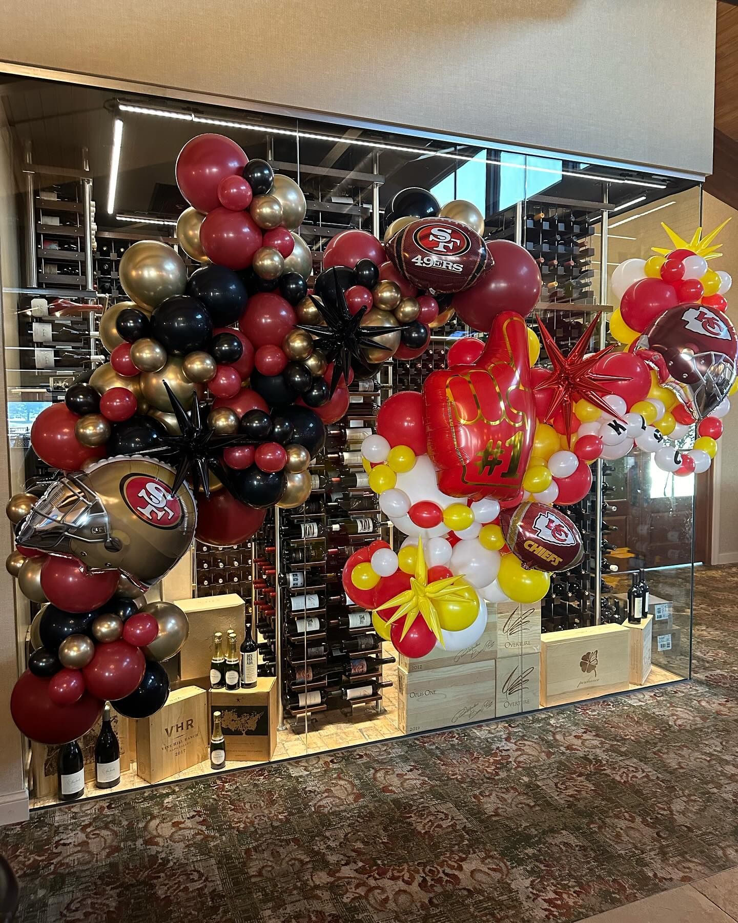 A bunch of balloons are hanging on a wall in a room.