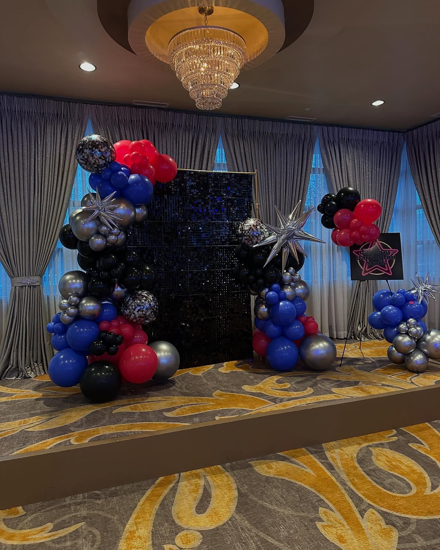 A room filled with balloons and a chandelier.