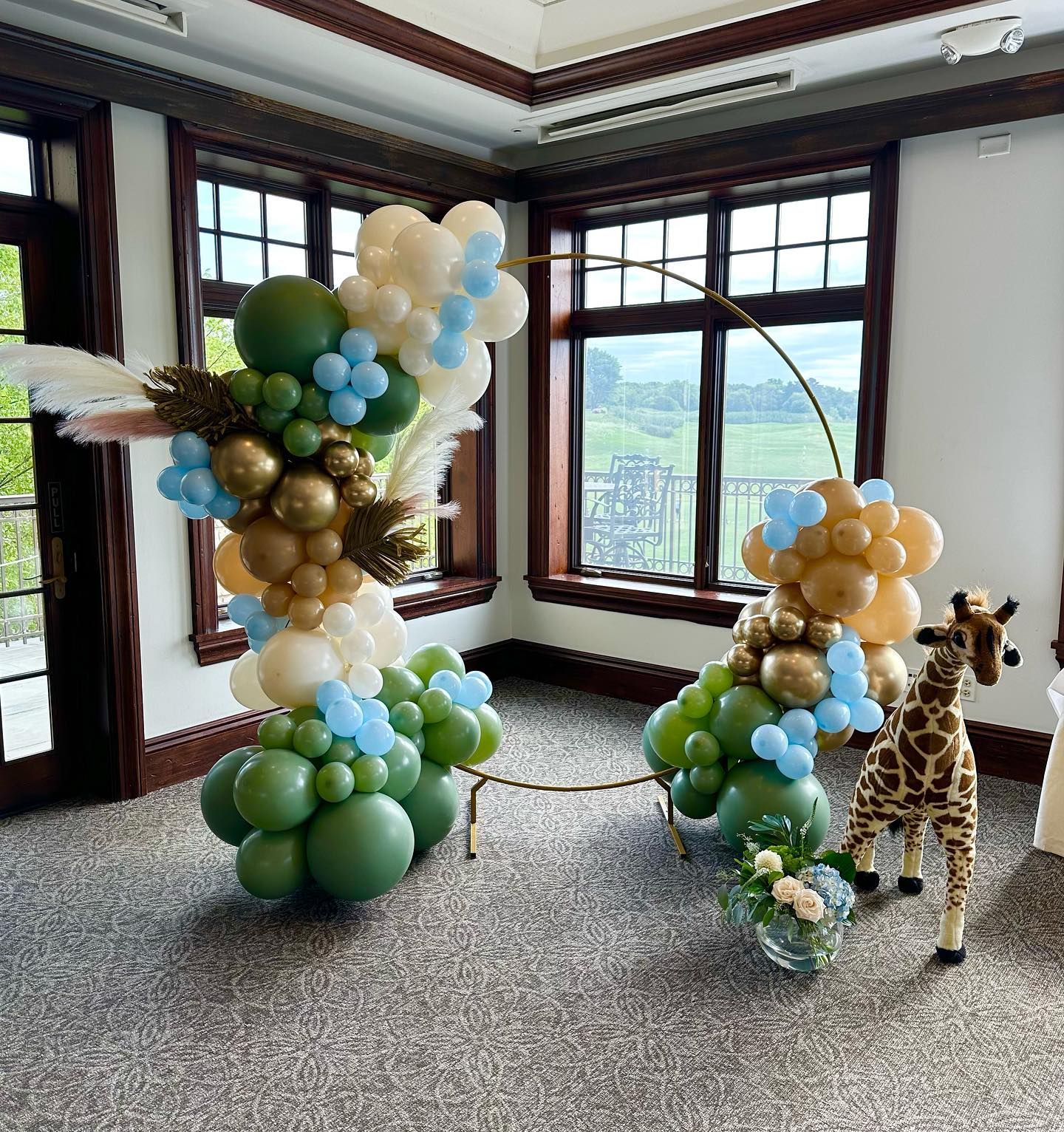 A room filled with balloons and a stuffed giraffe.