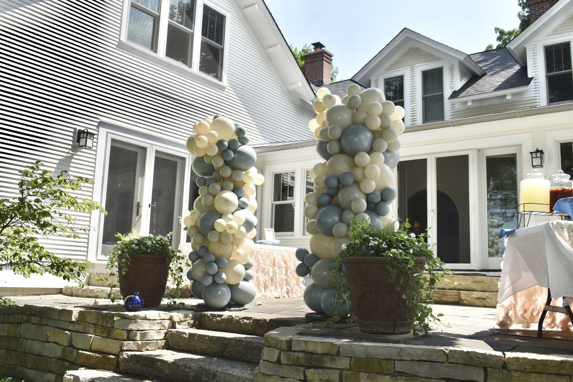 A bunch of balloons are sitting in front of a house.