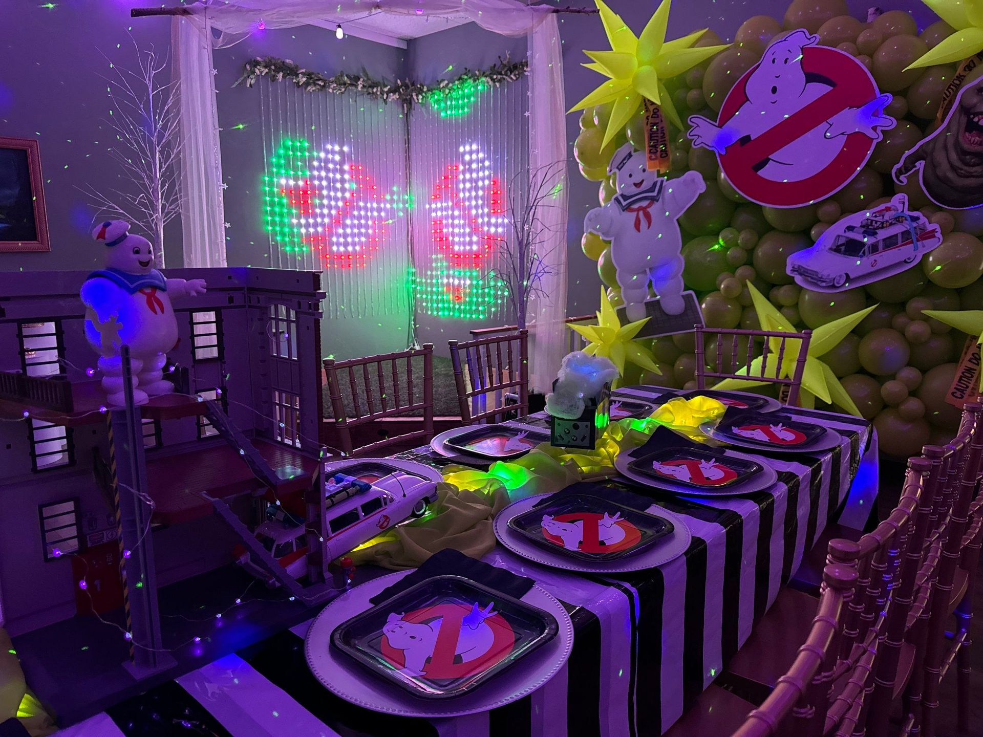 A room decorated for a ghostbusters party with a table and chairs.
