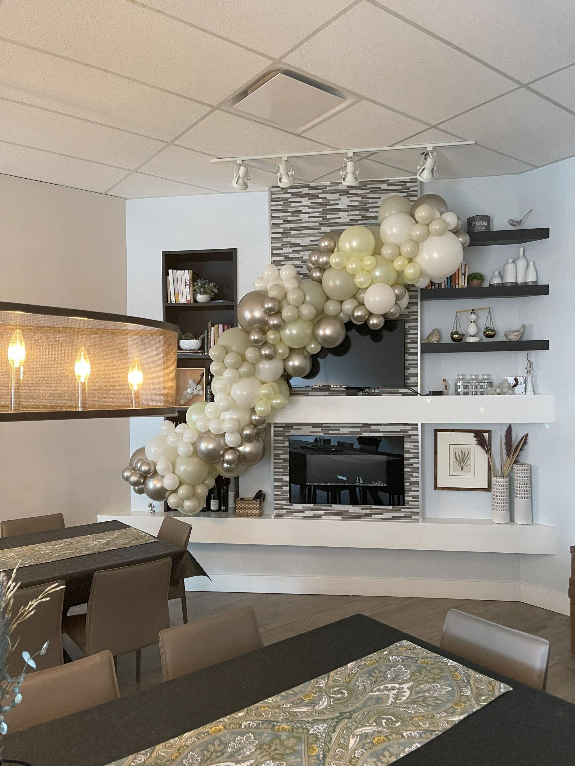 A living room with a table and chairs and balloons on the wall