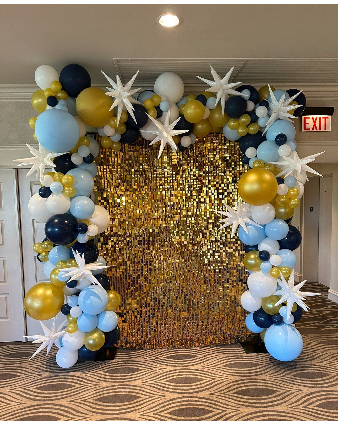 A room filled with balloons and a gold wall.