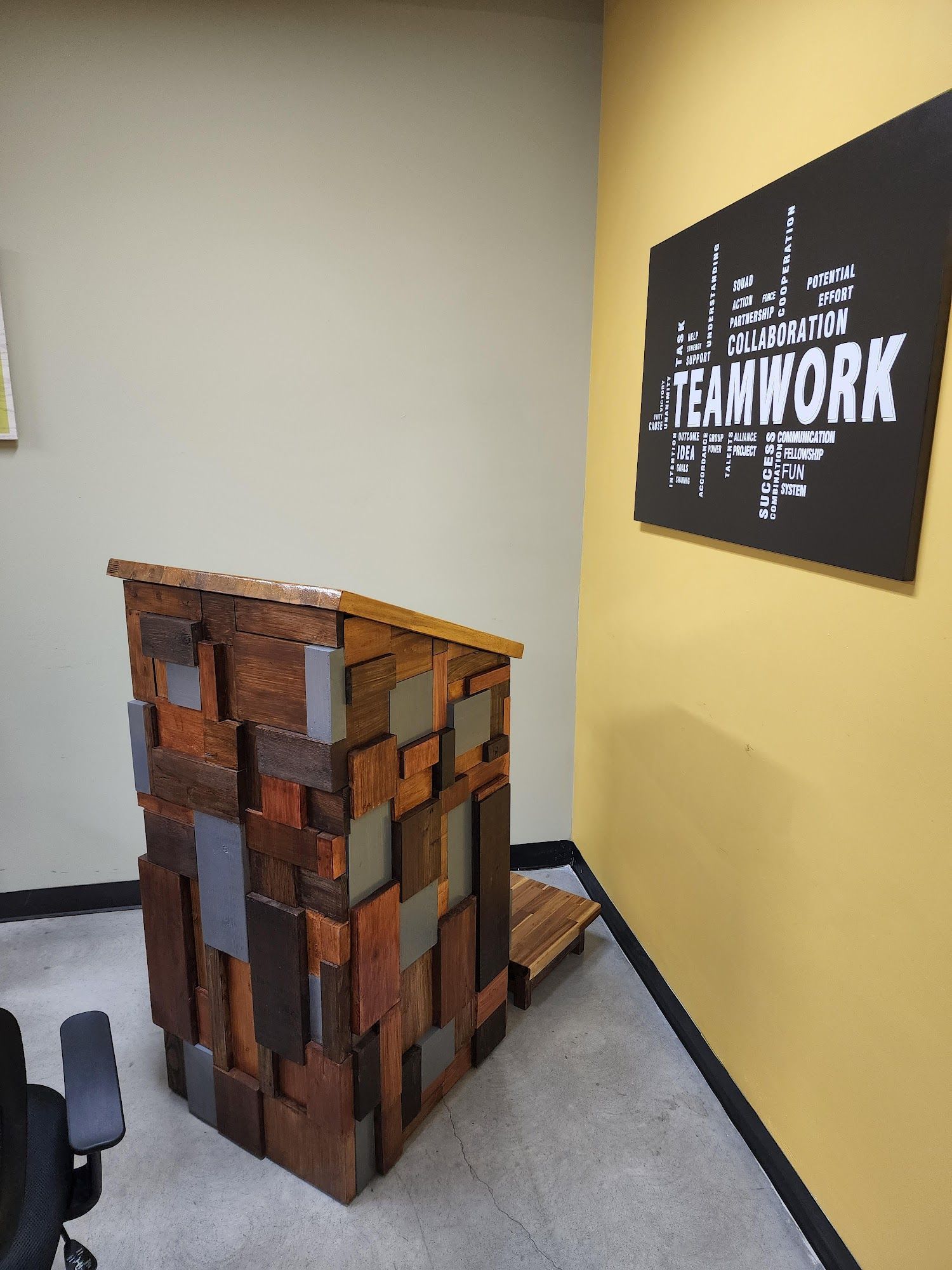 Wooden reception desk with a patchwork design next to a wall with a 