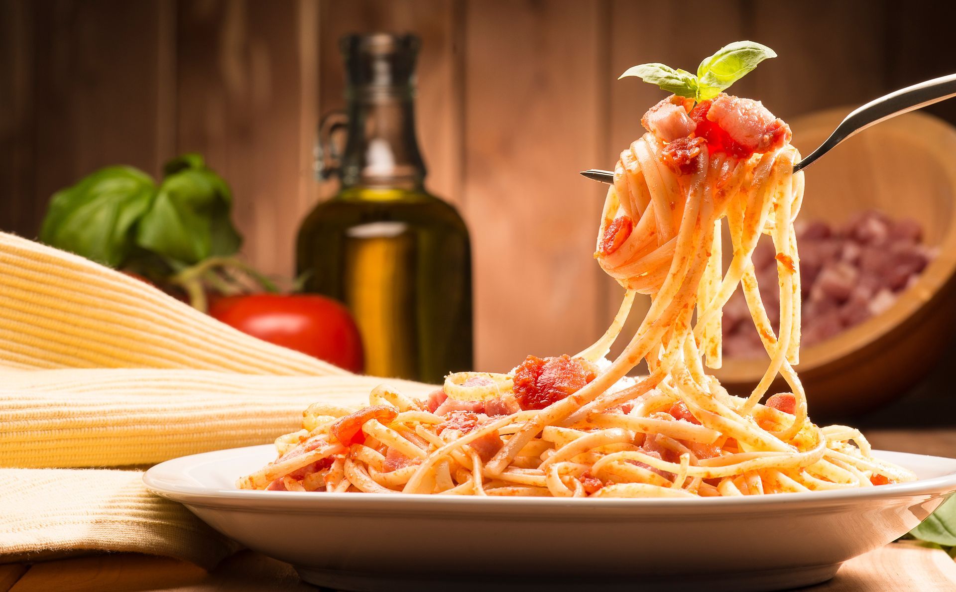 Spaghetti with amatriciana sauce in the dish on the wooden table