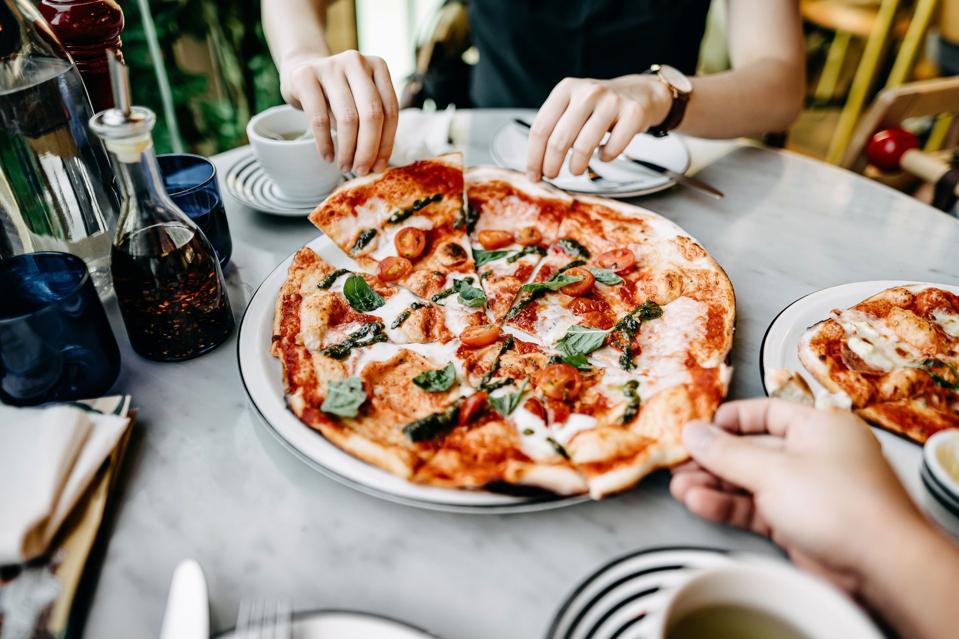 A couple sharing freshly made pizza and enjoying authentic Italian cuisine in a cozy restaurant.