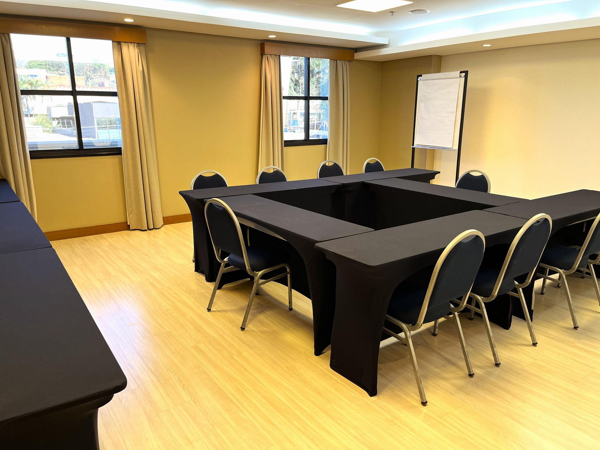 Há muitas mesas e cadeiras na sala.