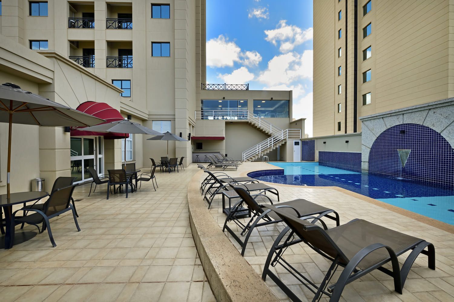 Piscina de Hotel com espriguiçadeiras.