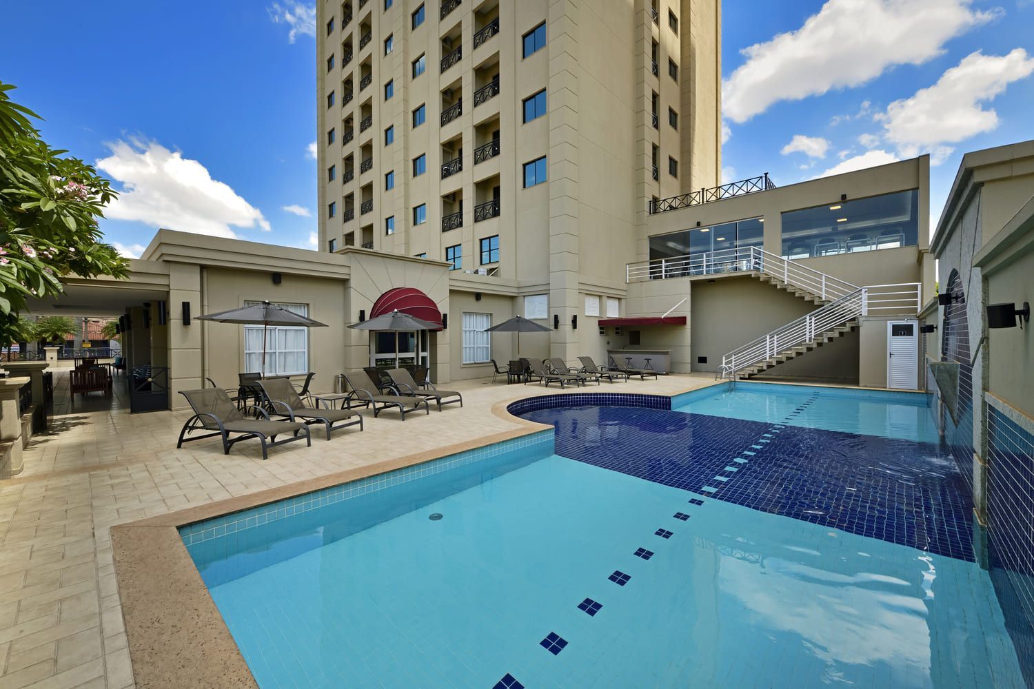 Há uma grande piscina em frente a um prédio.