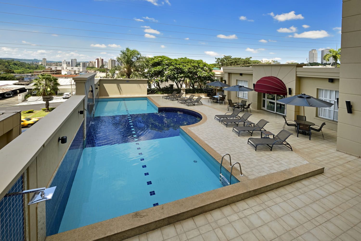 Uma grande piscina rodeada de cadeiras e guarda-sóis