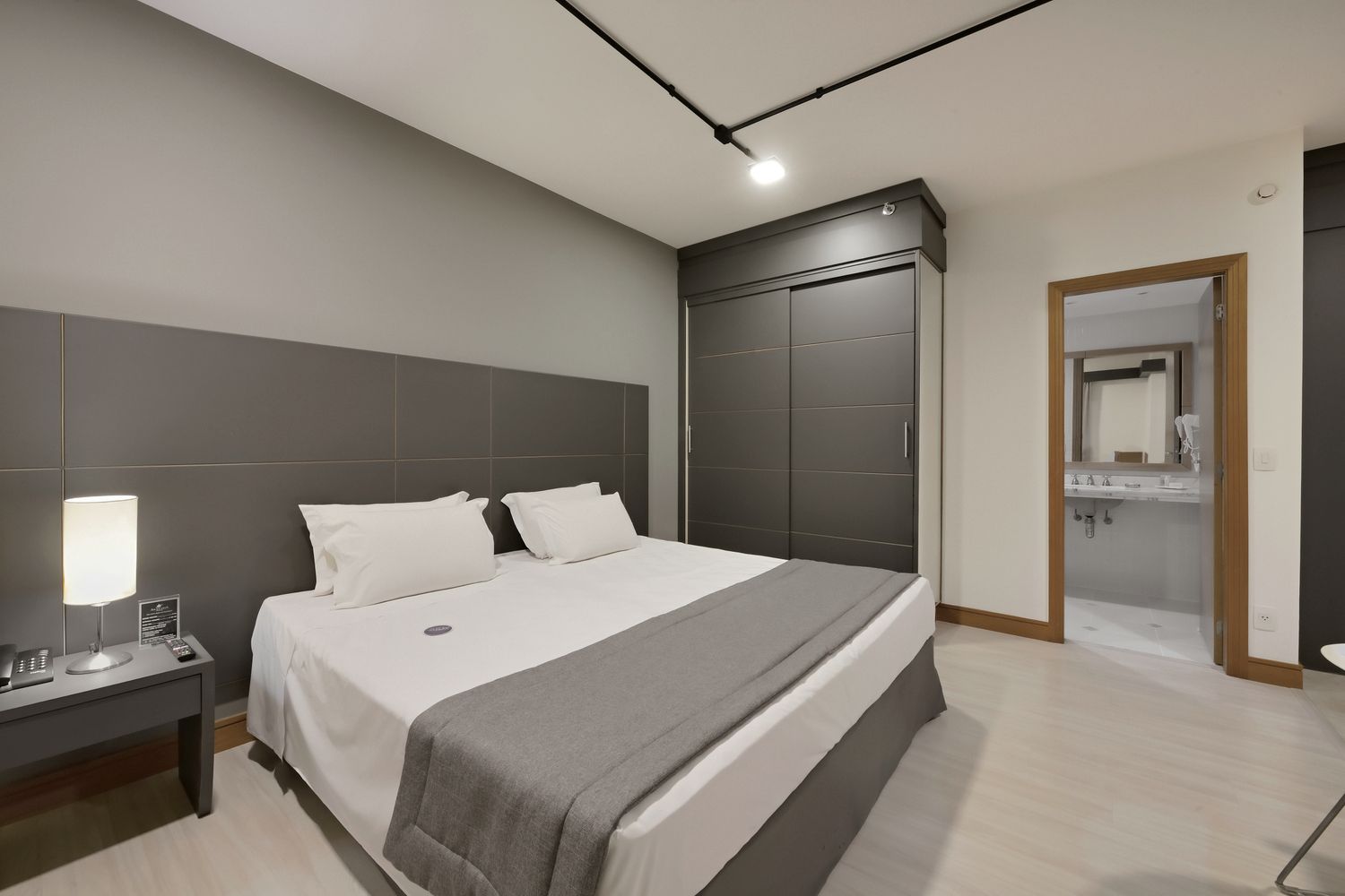 Um quanto de hotel com uma cama king size.