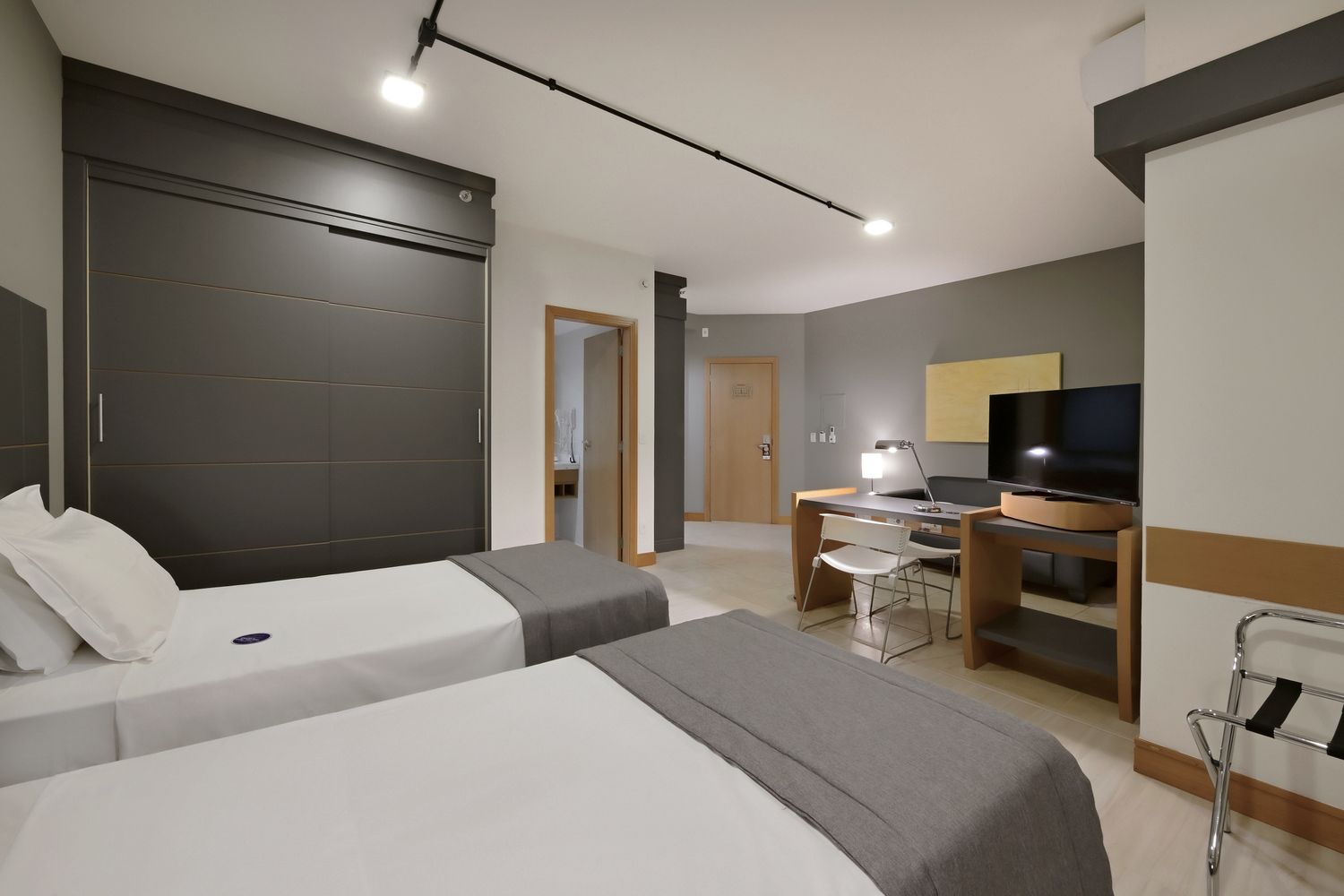 Um quarto de hotel com duas camas e uma televisão