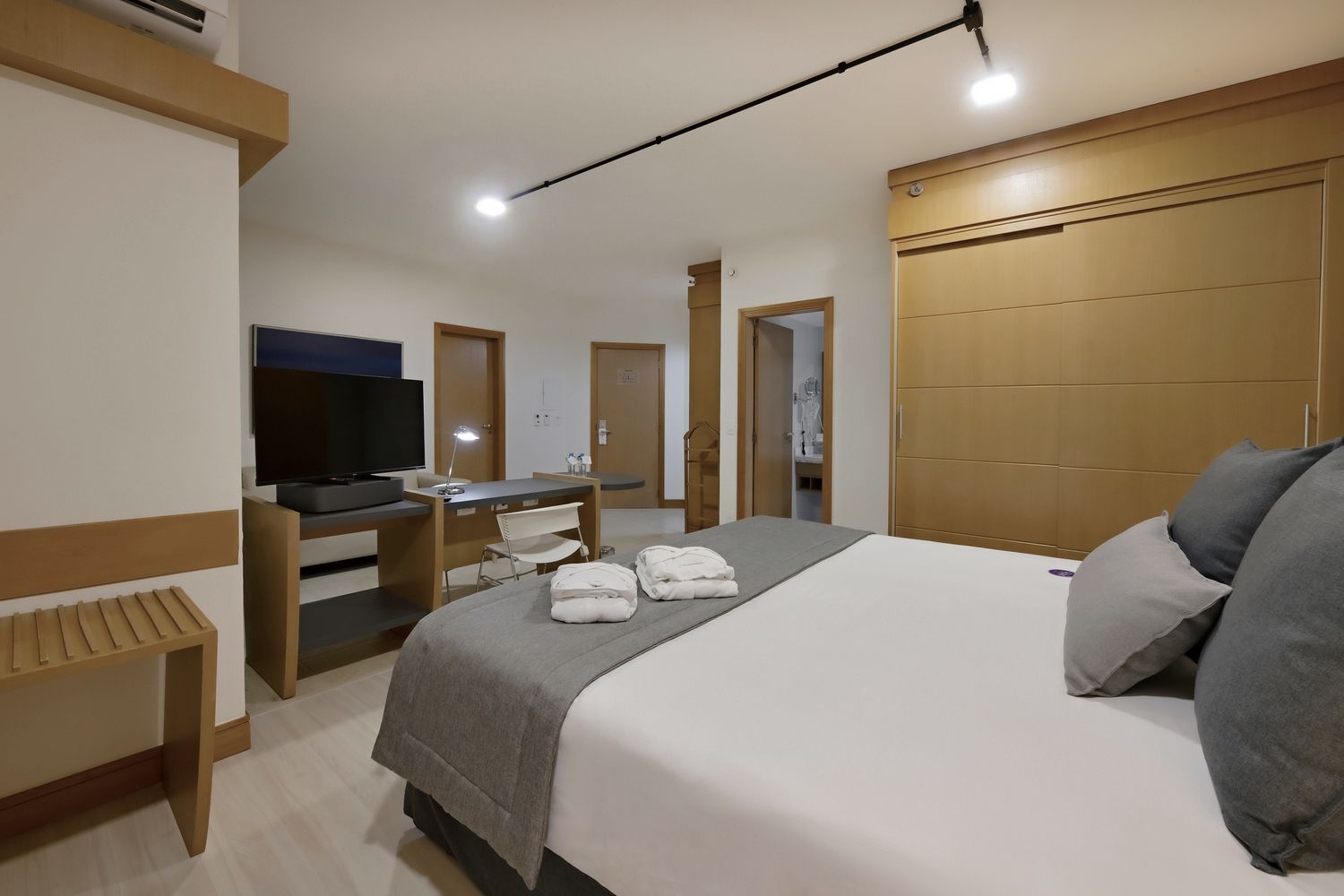 Um quarto de hotel com uma cama grande e uma TV de tela plana.