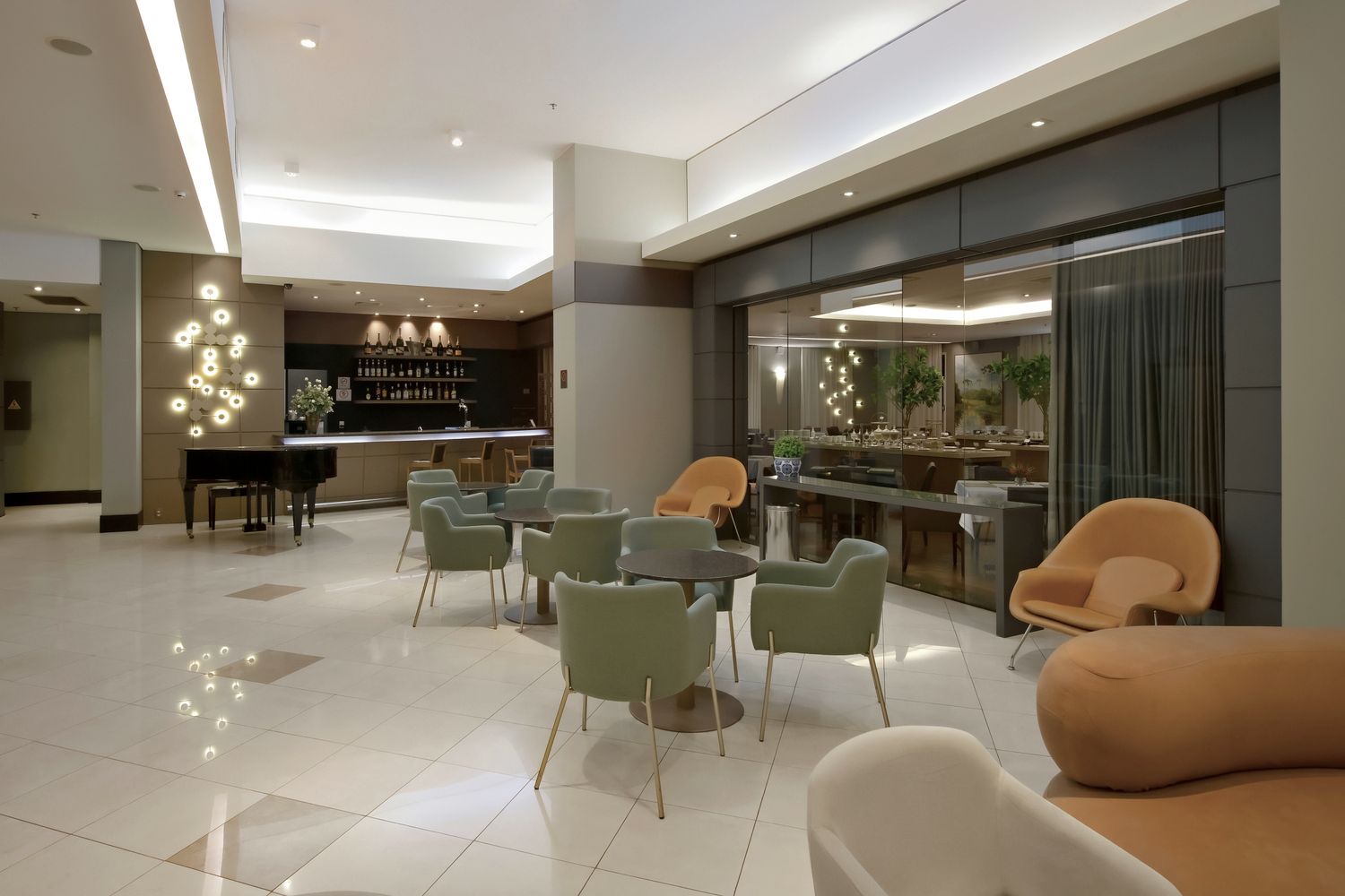 Há muitas cadeiras e mesas no lobby de um hotel.