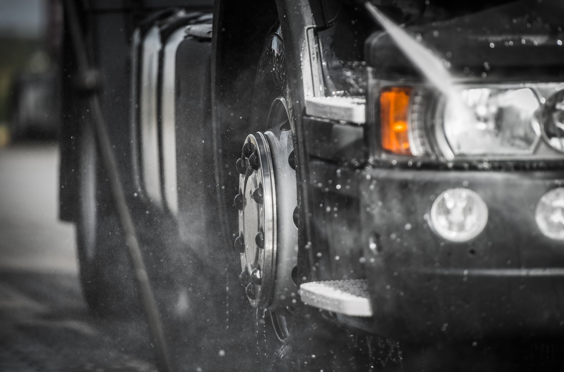 A truck is being washed with a high pressure washer.