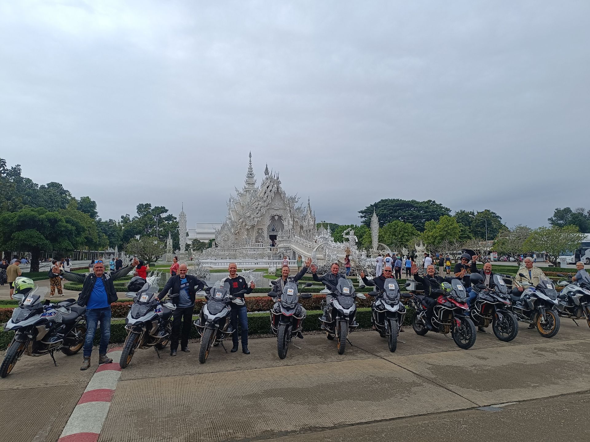 A group of people standing next to each other on motorcycles.