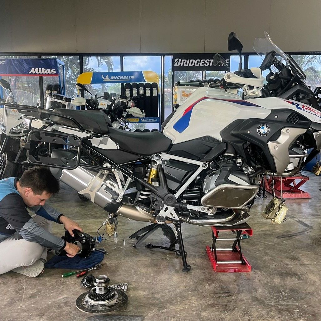 A man is working on a motorcycle in a garage.