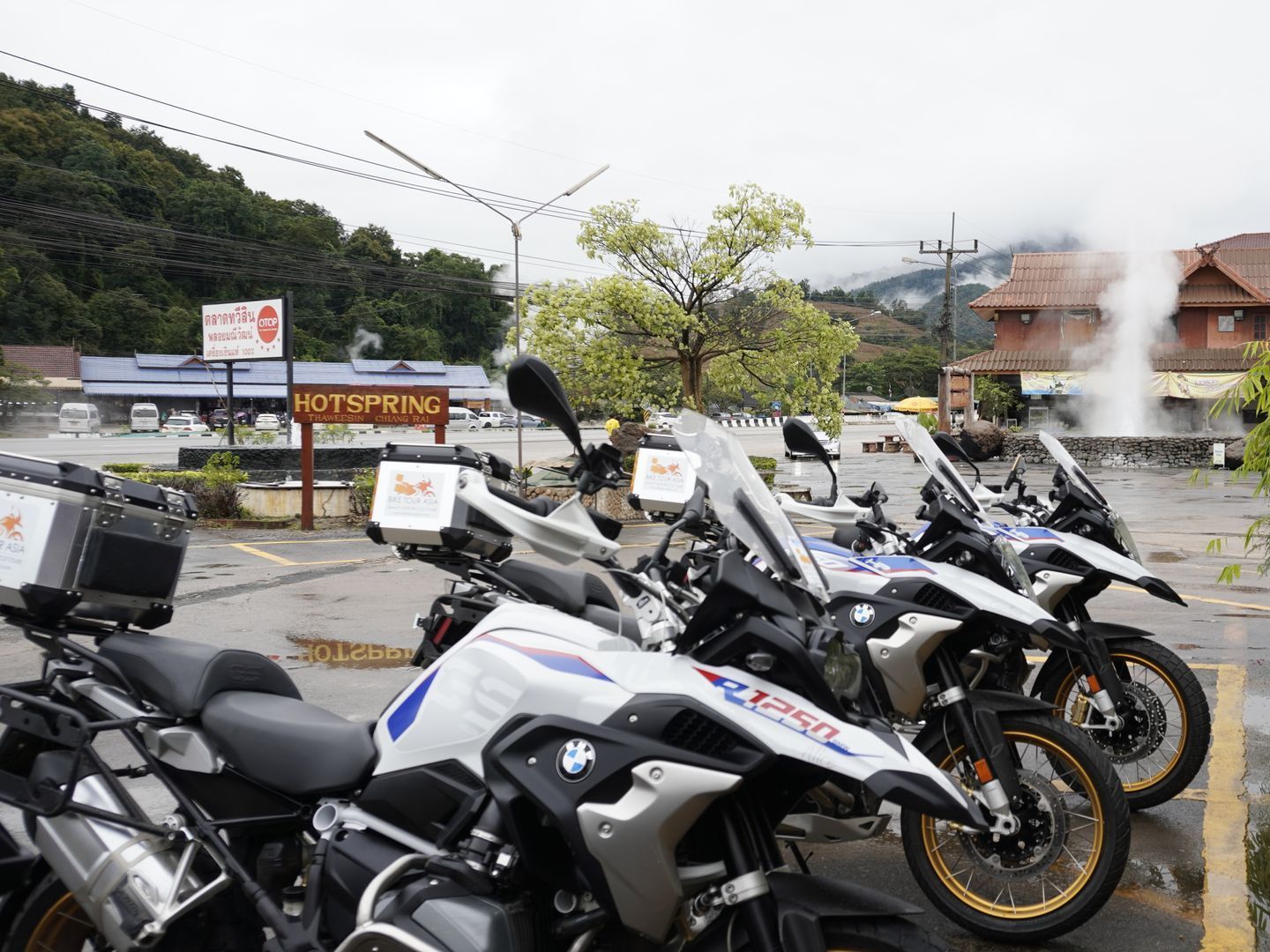 A row of motorcycles are parked in a parking lot.