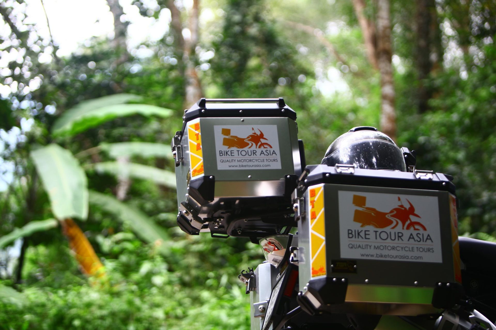 Close-up of BMW adventure motorcycle with Bike Tour Asia pannier boxes in the jungle