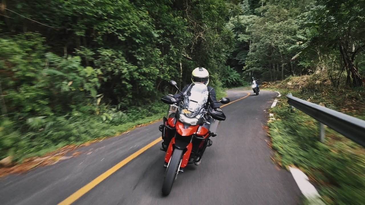 Motorcycle riders navigating a winding jungle road in northern Thailand during a Bike Tour Asia tour