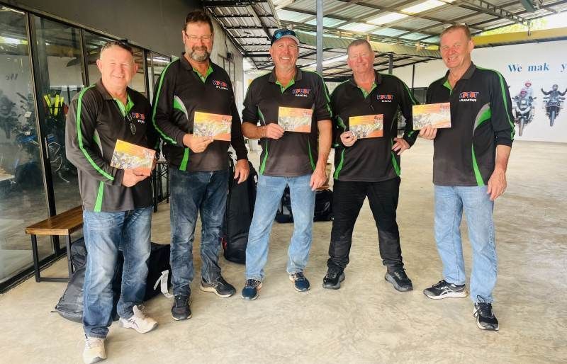 A group of Bike Tour Asia riders posing with their tour certificates at the end of a motorcycle trip in Thailand.