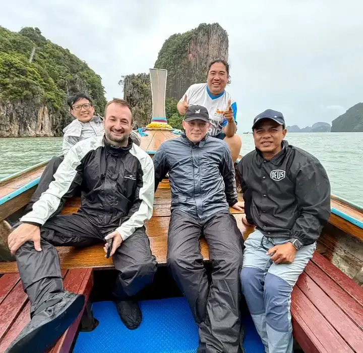 Bike Tour Asia riders on a longtail boat exploring limestone cliffs at Phang Nga Bay, southern Thailand