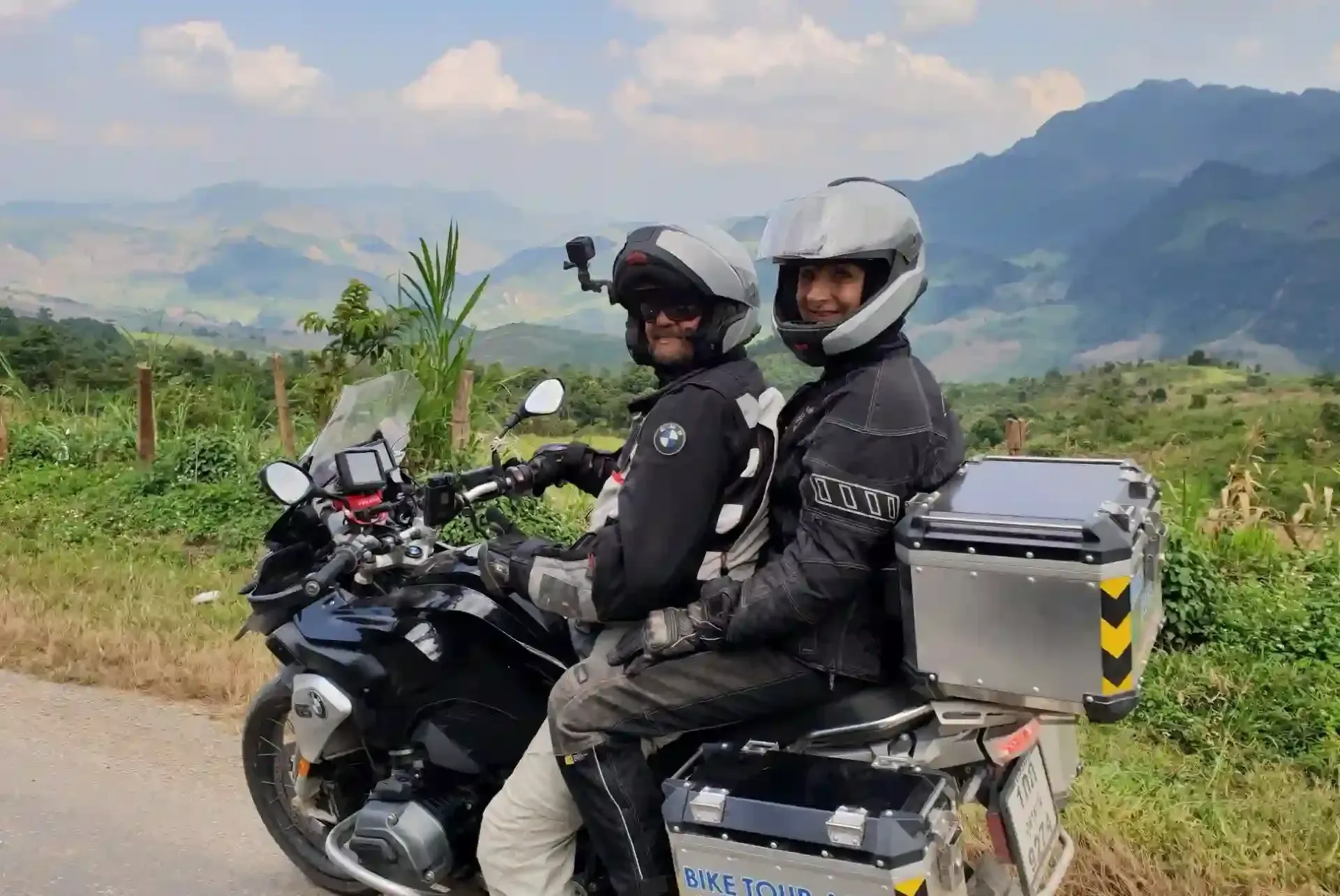 Couple riding a BMW touring motorcycle enjoying scenic mountain views in northern Thailand