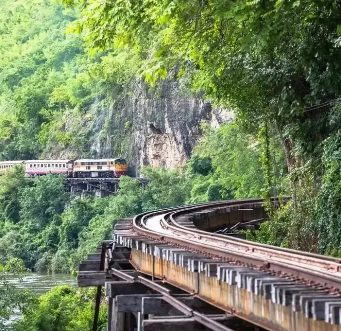 Train crossing the historic Death Railway bridge over the River Kwai in Kanchanaburi, Thailand