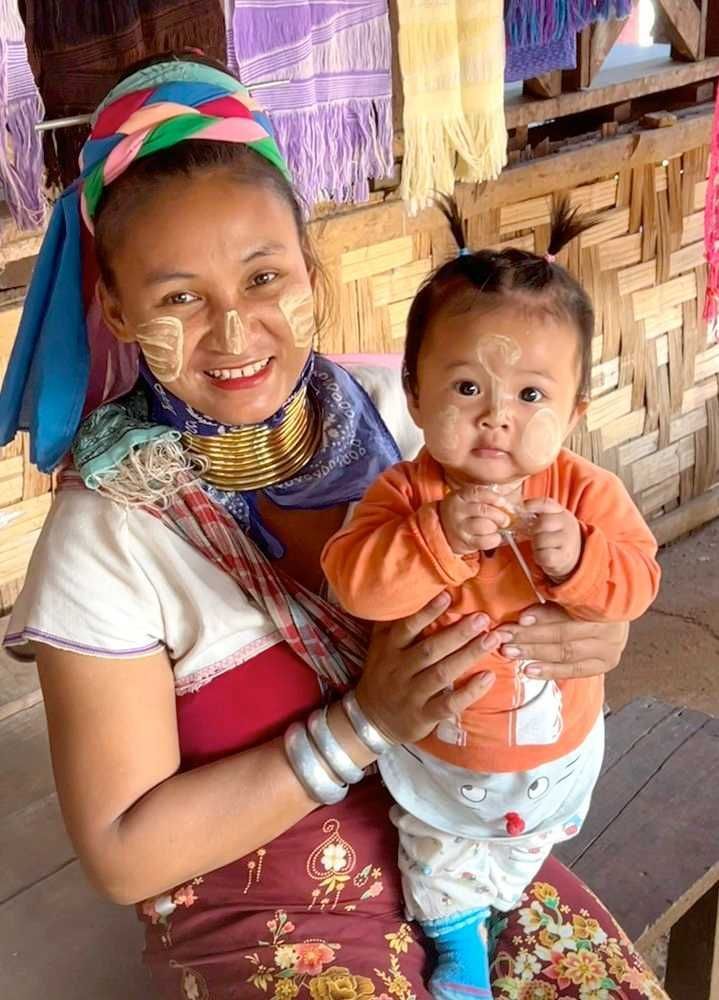 Kayan village mother holding her child during a cultural visit in Northern Thailand