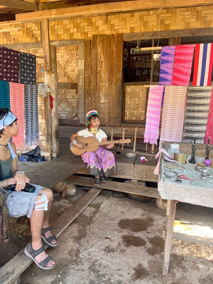 Kayan village child playing traditional music during a cultural visit in Northern Thailand