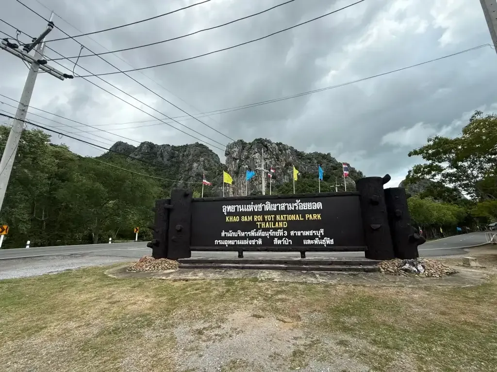 Entrance sign of Khao Sam Roi Yot National Park with limestone mountains in Prachuap Khiri Khan, Thailand