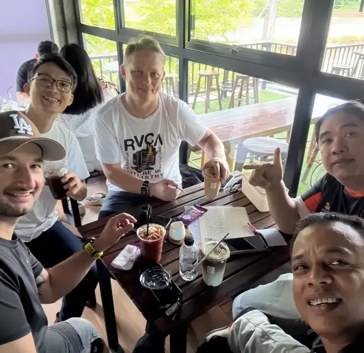 Group of motorcycle riders relaxing with coffee during a break on the Chiang Mai to Phuket tour in Thailand