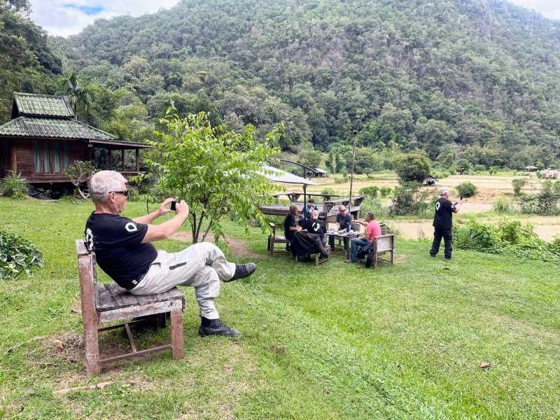 Motorcycle tour riders relaxing at a rural countryside stop in Northern Thailand